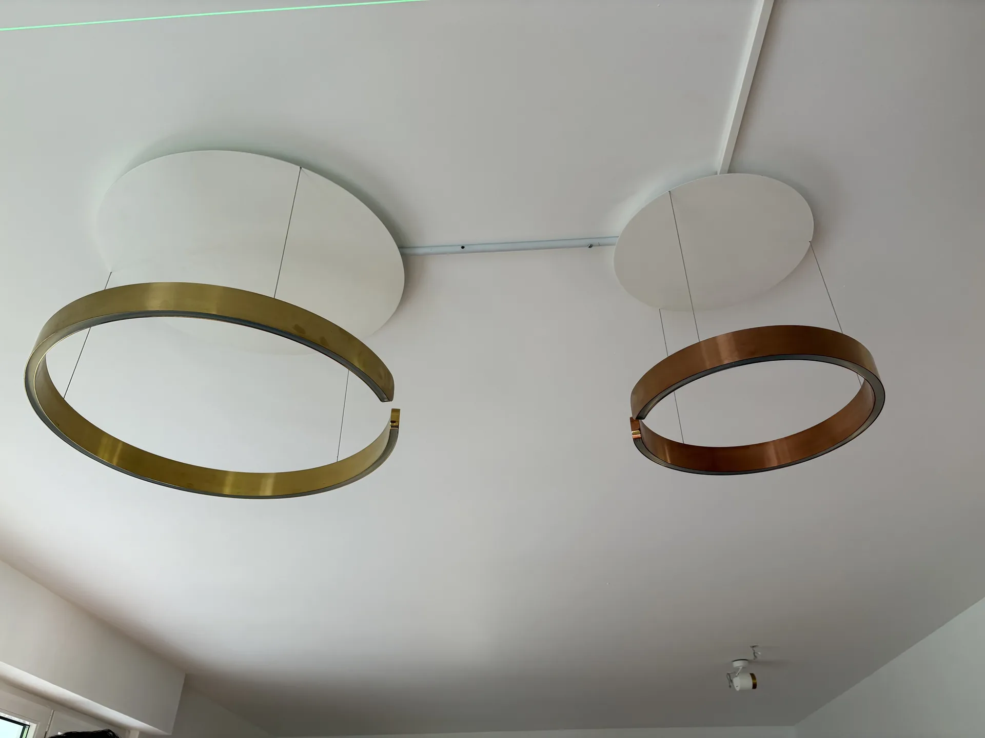 Design-Pendelleuchten in Gold und Kupfer an wei&szlig;er Decke